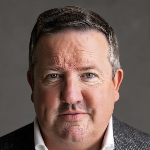 Steve Foster, who builds ContactRoll, smiling slightly, with short dark hair, in a grey tweed jacket and an open-collared white shirt.